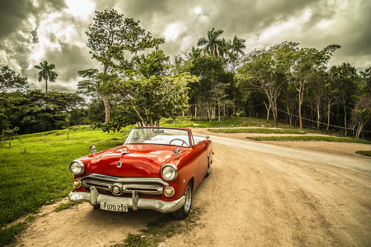 Coche clásico descapotable en camino de tierra. 
